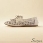 Mocassim em couro legítimo com detalhe clássico de laço, na cor ônix, destacando-se como um mocassim com laço elegante e confortável.