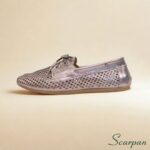 Mocassim em couro legítimo com detalhe clássico de laço, na cor ônix, destacando-se como um mocassim com laço elegante e confortável.