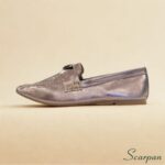 Mocassim em Couro Verniz Prata Velho, também chamado de Mocassim em Couro Ônix, visto de cima, com detalhe em fivela metálica sobre o cabedal e solado rasteiro. A cor metalizada tem um brilho suave de ônix.