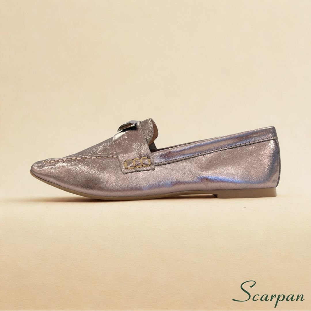 e2d3d05c9329db53425a68912d71e005.jpg Mocassim em Couro Verniz Prata Velho, também chamado de Mocassim em Couro Ônix, visto de cima, com detalhe em fivela metálica sobre o cabedal e solado rasteiro. A cor metalizada tem um brilho suave de ônix.