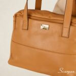 Bolsa de couro com divisórias modelo Cibeli na cor caramelo da Scarpan com detalhe de alça de ombro e logo dourado em Detalhes