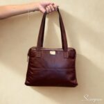 Bolsa de couro com divisórias Cibeli cor pinhão em couro legítimo com detalhes dourados. Foto frontal