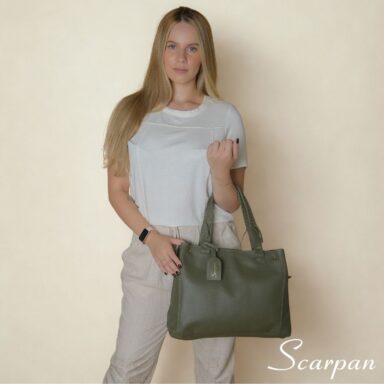 Bolsa feminina de couro legítimo verde modelo sacola Camila sendo usada no ombro com look casual elegante