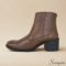Detalhe lateral de bota de cano curto em couro com pequenas tachas metálicas