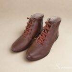 Visão superior de par de botas de couro cano curto feminina na cor Marrom
