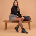 Look elegante de trabalho com saia cinza e blusa preta e a bota de couro Preta Serena