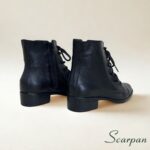 Visão traseira mostrando o zíper lateral funcional da bota feminina em couro preta