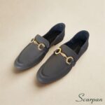 Visão superior de par de mocassins de couro cinza com enfeite bridão dourado