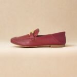 Movimento de calce com mocassim de couro vinho com fivela dourada e calça bege