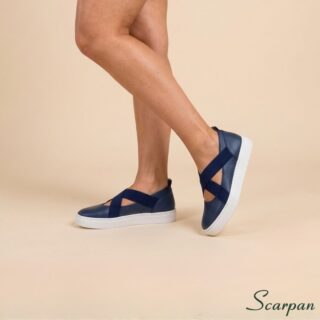 Visao lateral de tenis feminino de couro marinho sem forro com solado branco